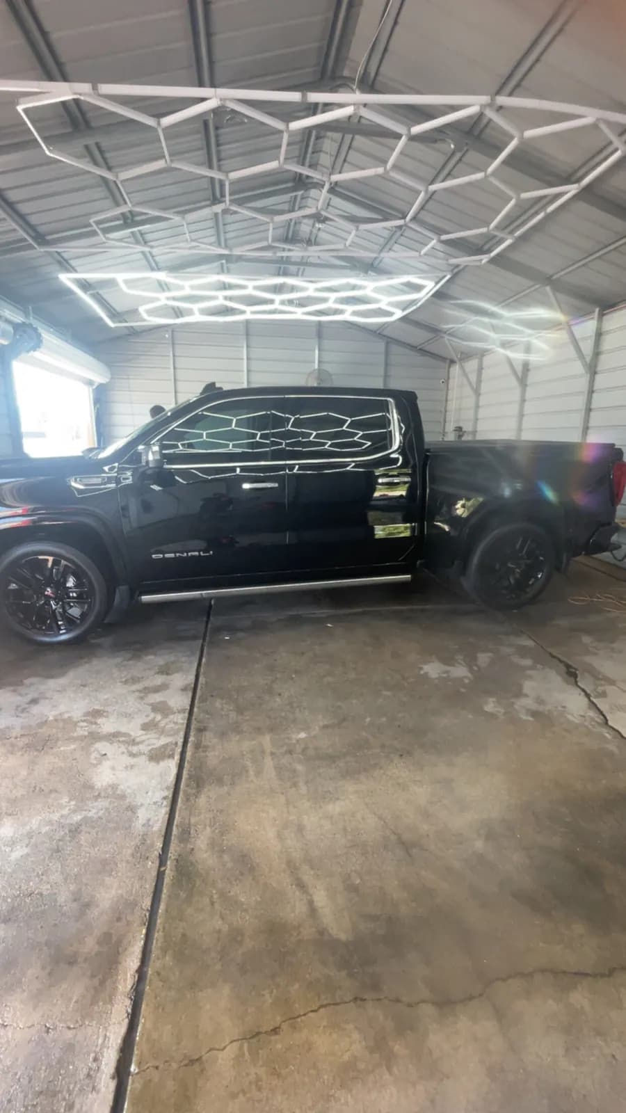 Soap patterns on a black truck mid-wash