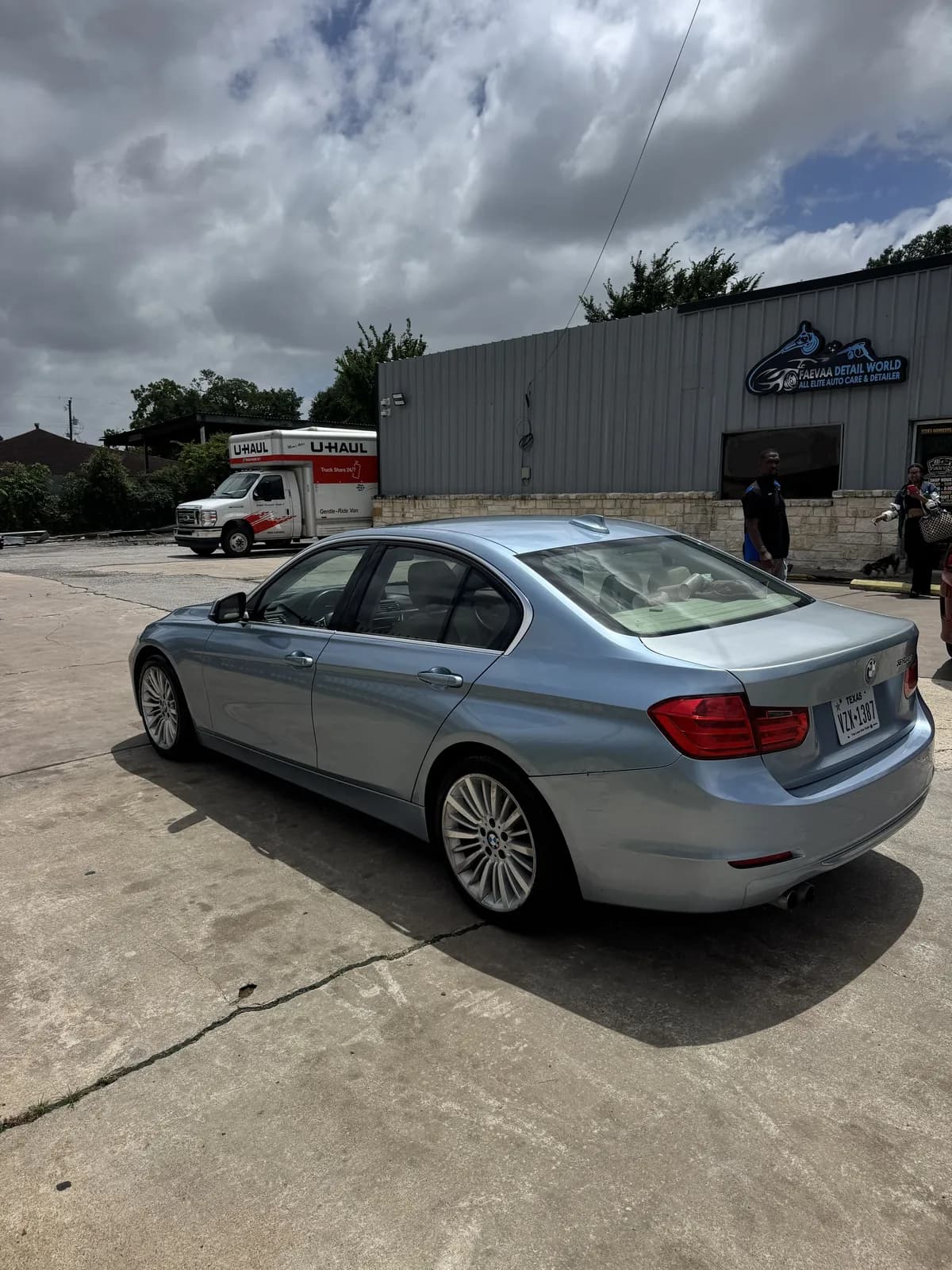 Ice-blue BMW 3 Series after a hand wash, rear view