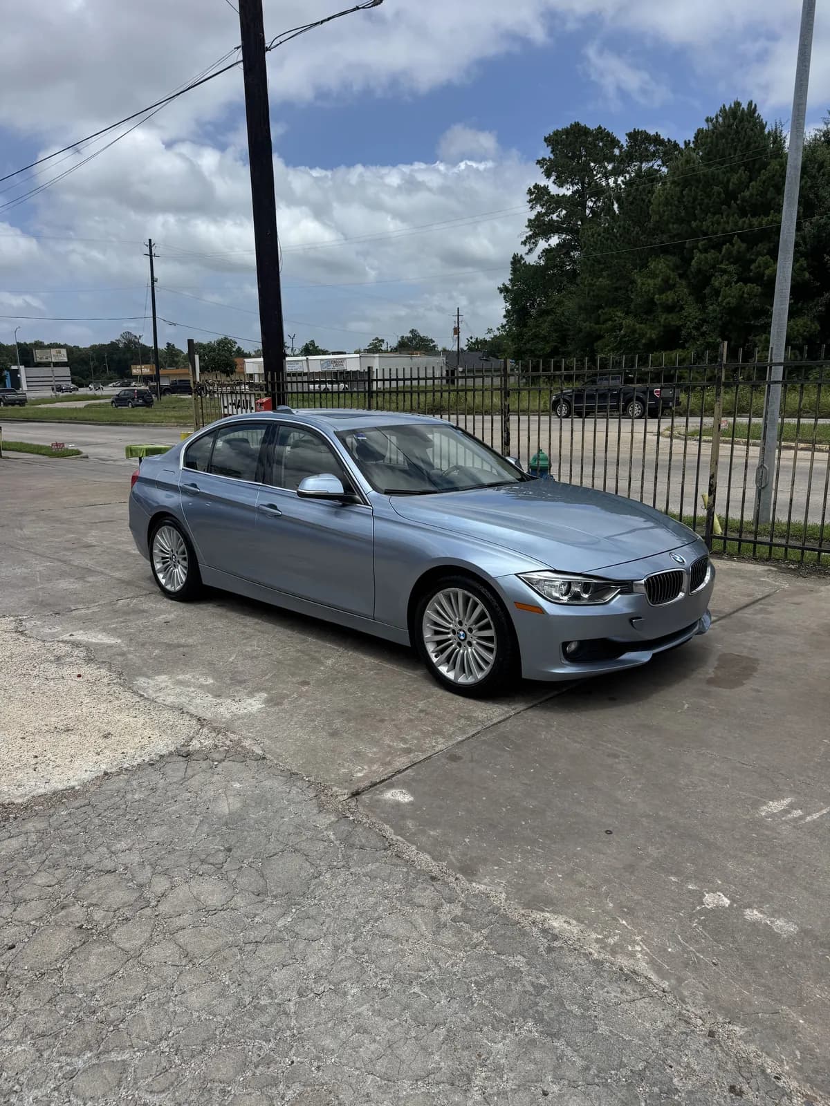 Ice-blue BMW 3 Series after a hand wash, side view