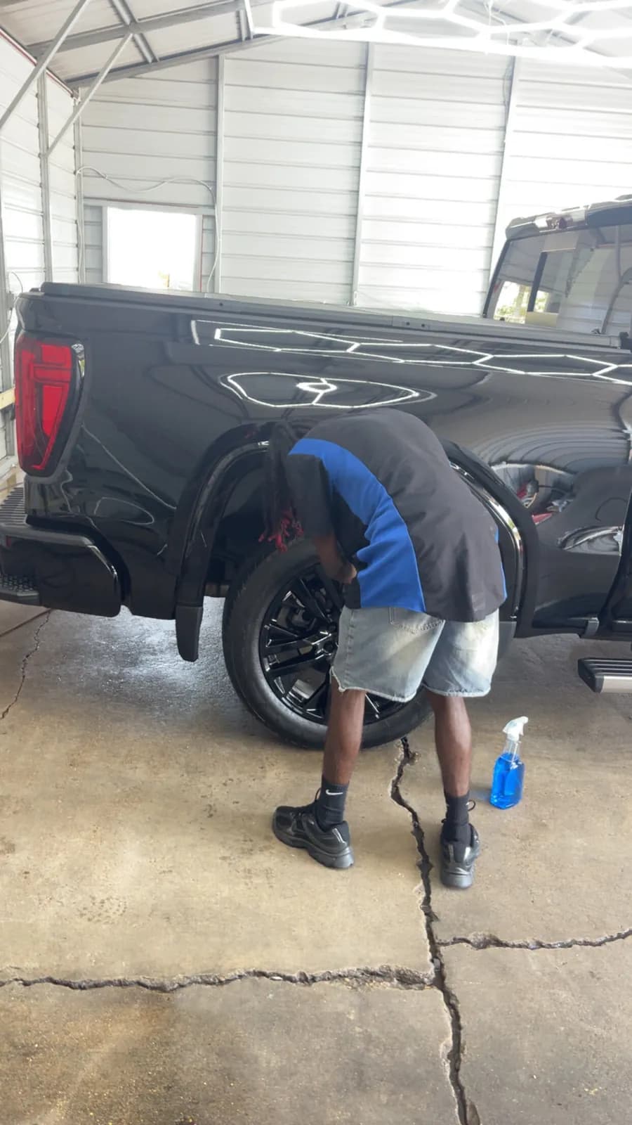A Faevaa detailer cleaning a black truck's wheels